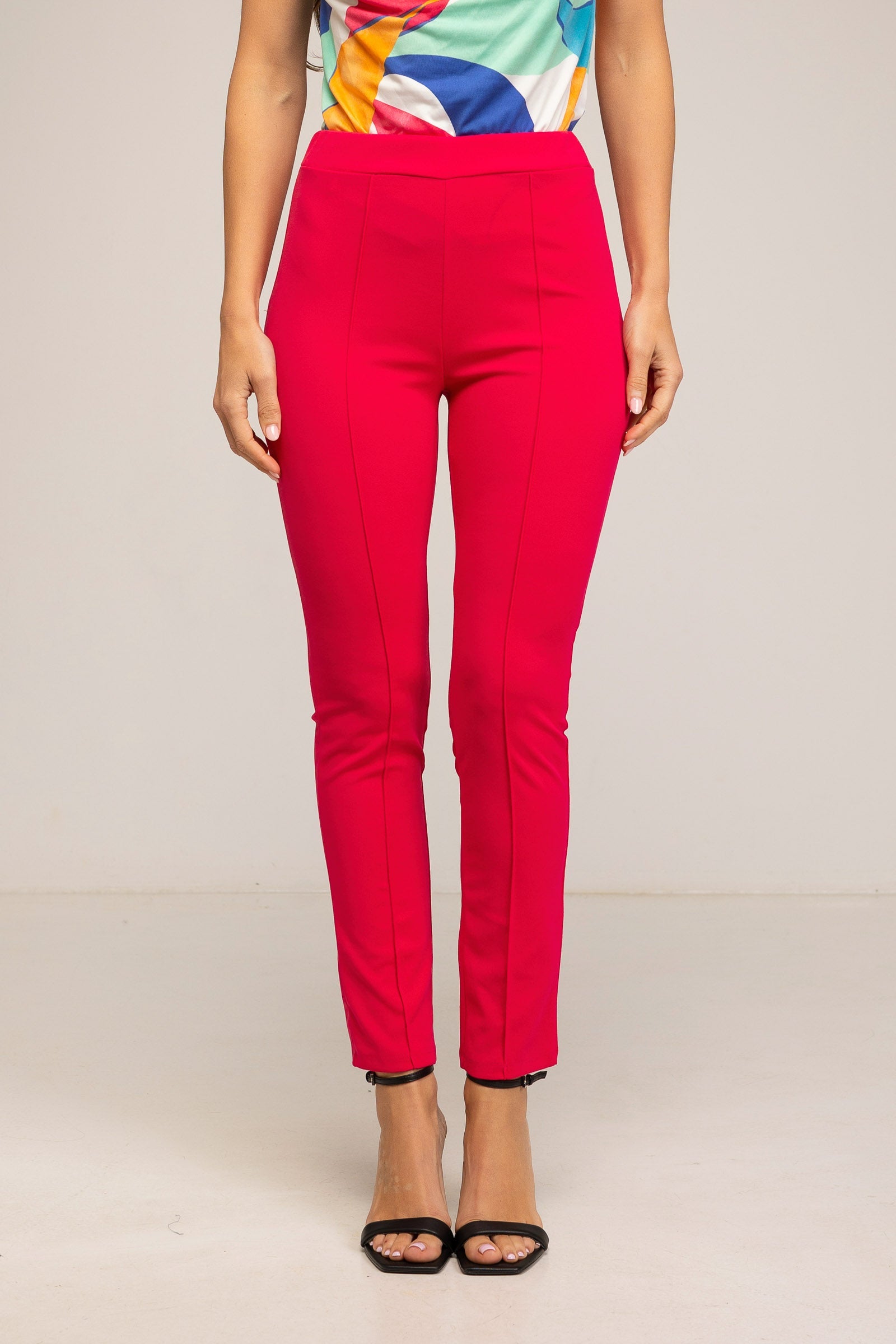 Red pants worn by a person on a plain background