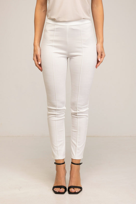 White pants worn by a person on a plain background