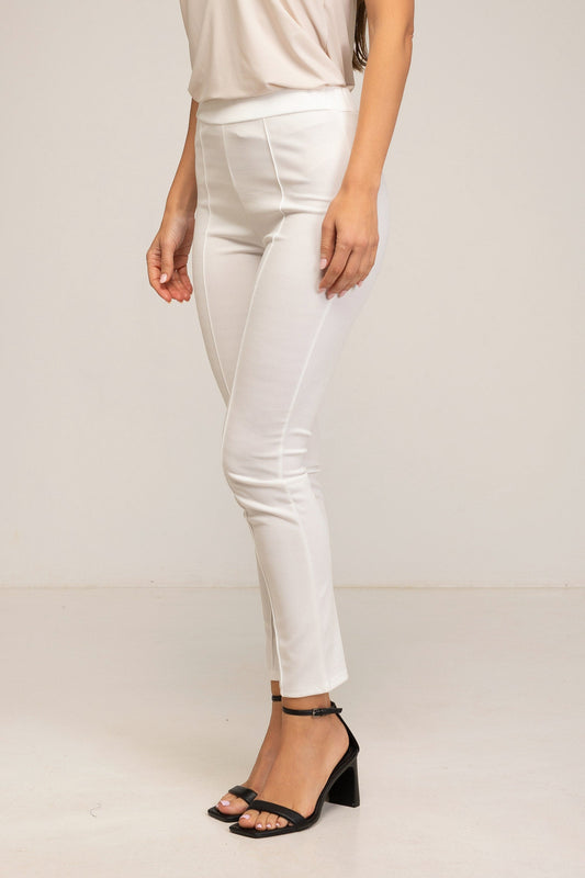 Person wearing white pants and black sandals on a plain background