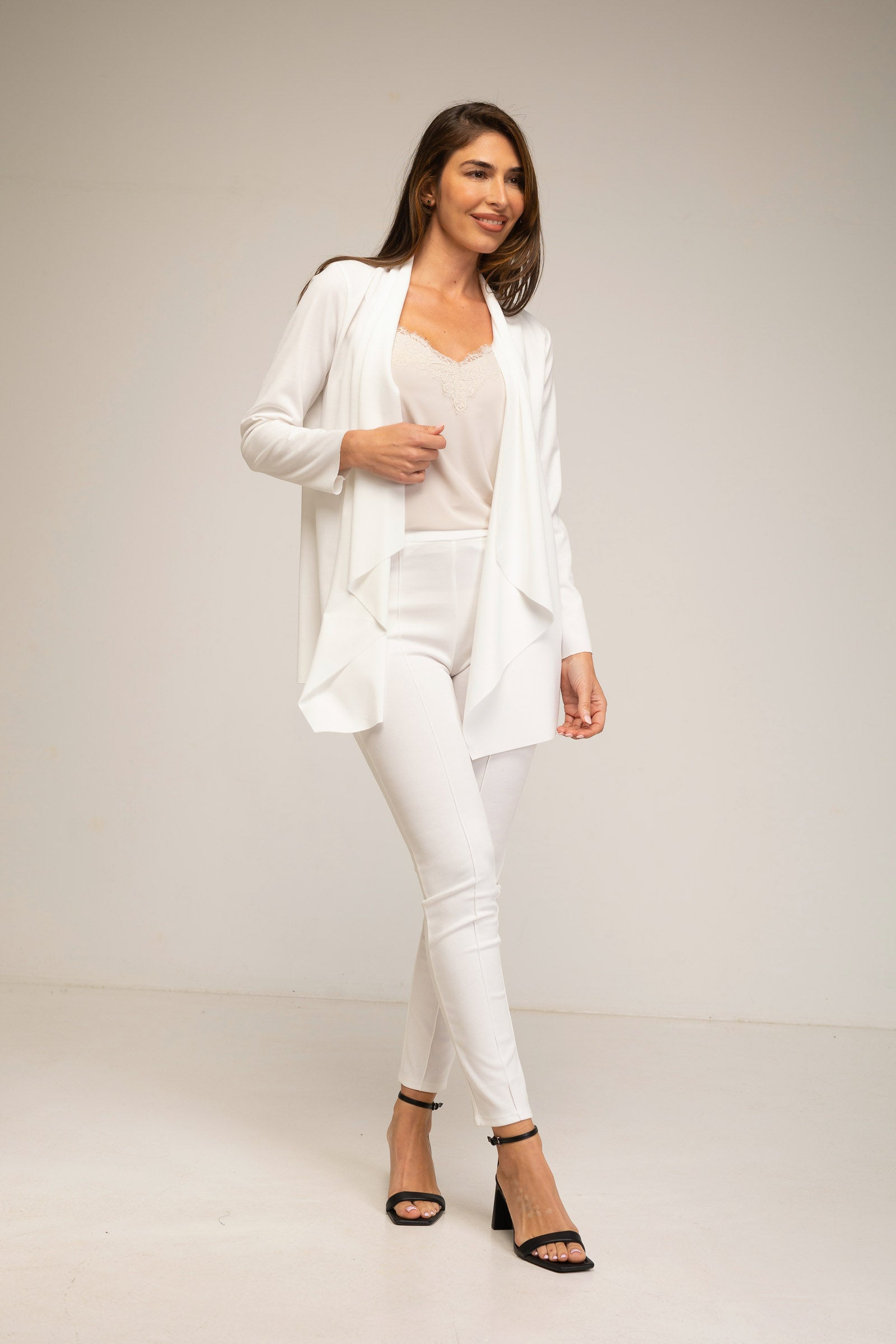 Woman wearing a white outfit on a plain background