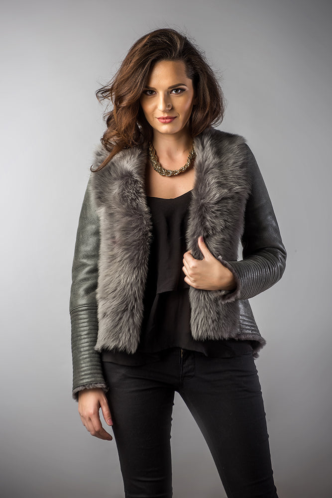 Woman wearing a gray fur-trimmed jacket on a gray background