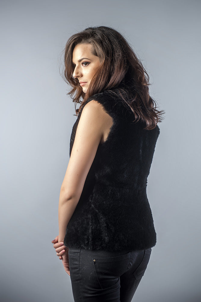 Woman wearing a black sleeveless top against a gray background