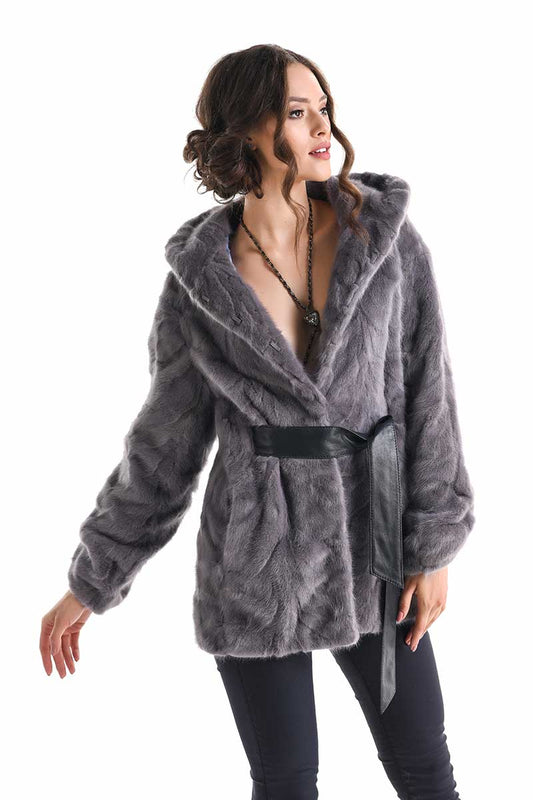 Woman wearing a gray fur coat with a hood on a white background