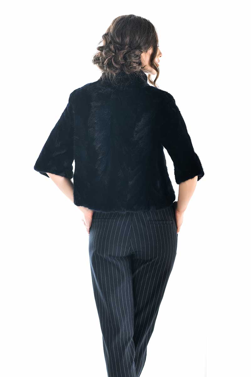 Person wearing a navy jacket and pinstripe pants on a white background