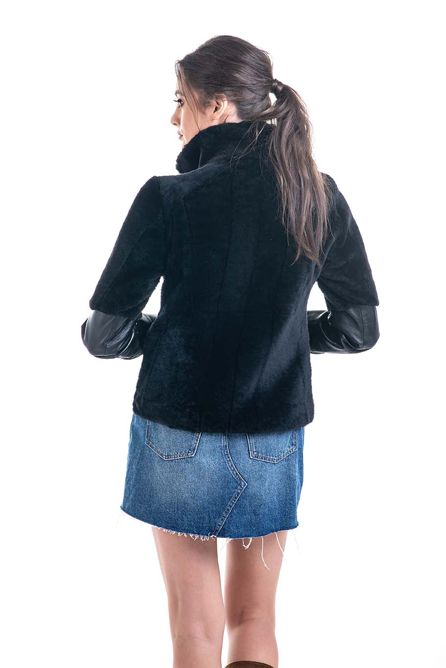 Woman wearing a black jacket and blue denim skirt on a white background