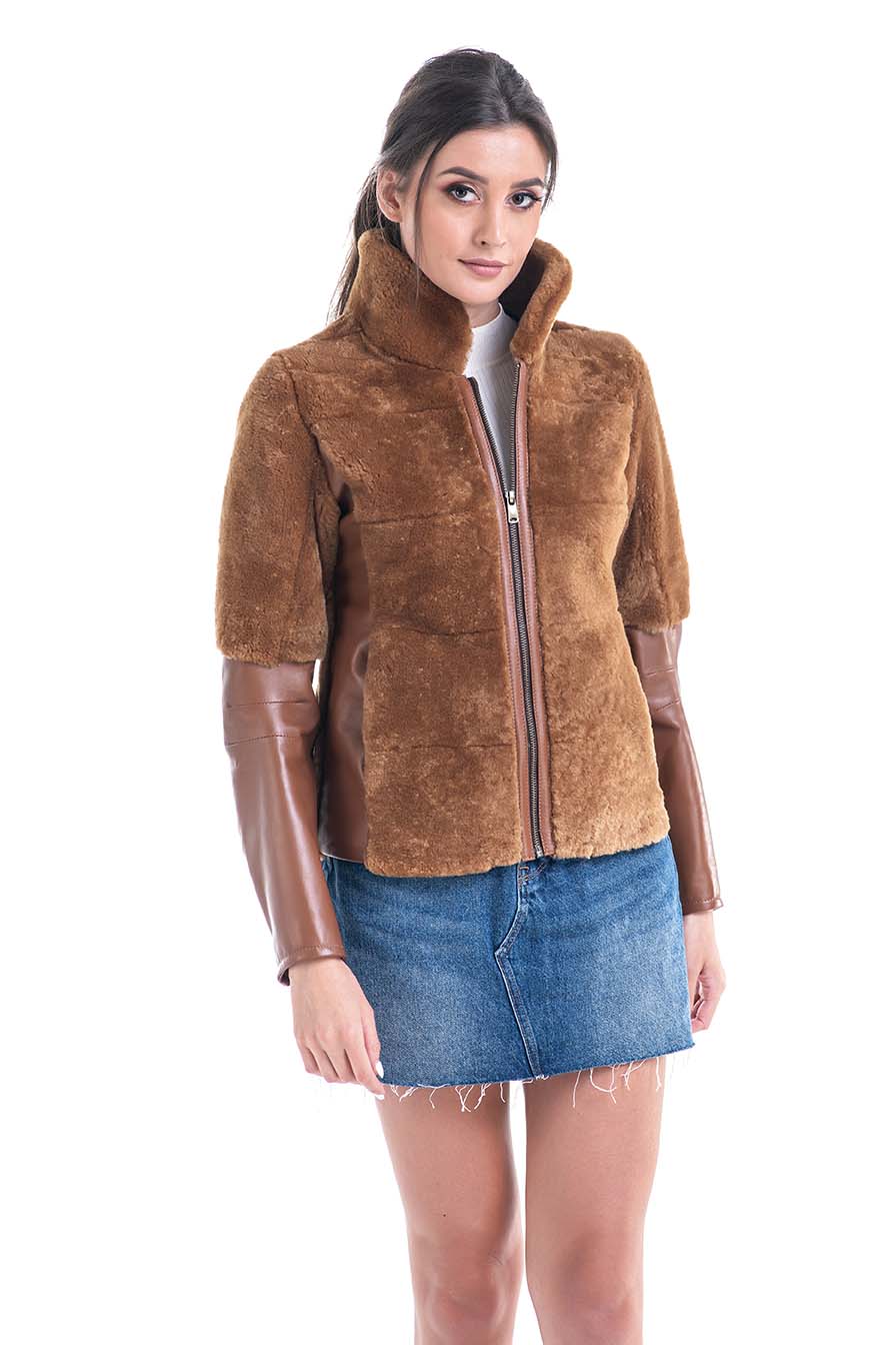 Woman wearing a brown suede jacket with leather sleeves on a white background