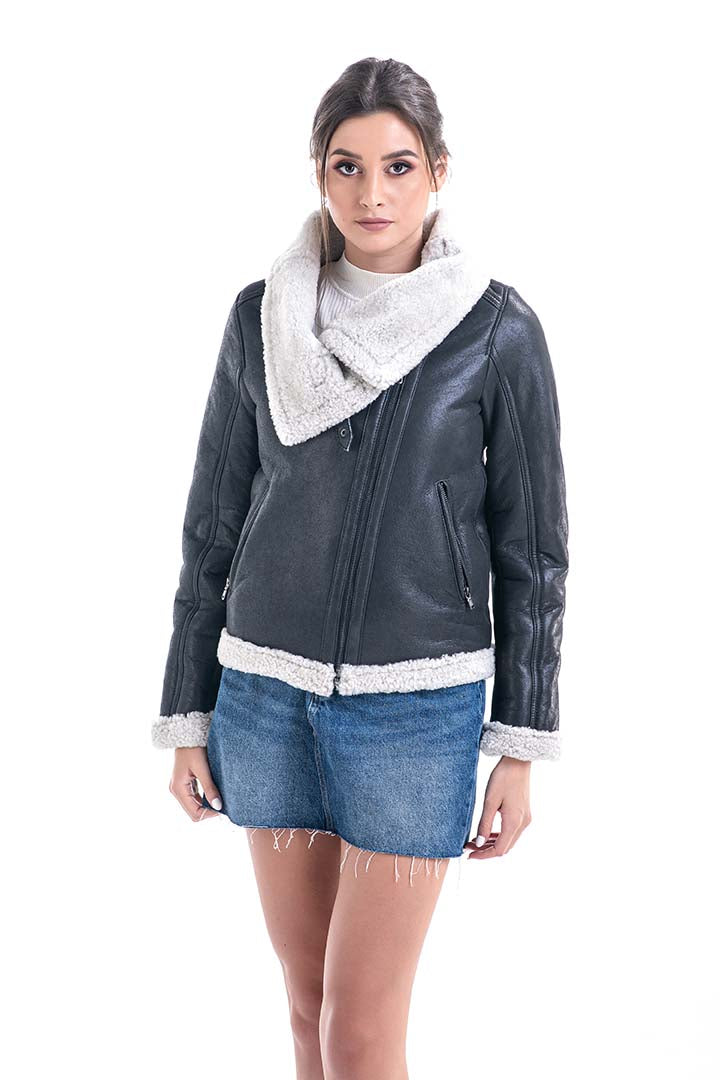 Woman wearing a dark gray leather jacket with white trim, denim shorts, and a white scarf on a white background.