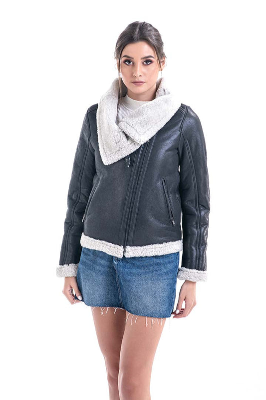 Woman wearing a dark gray leather jacket with white trim, denim shorts, and a white scarf on a white background.