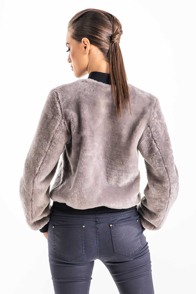 Woman wearing a gray textured jacket on a white background