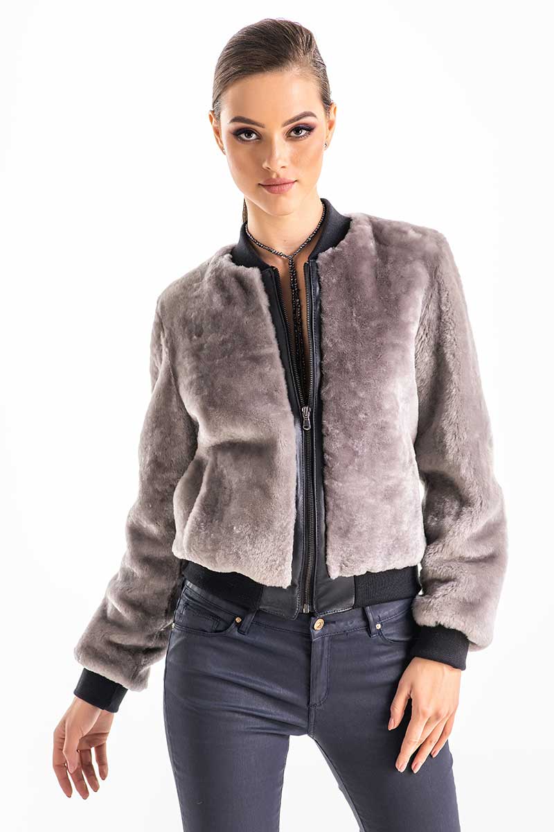 Woman wearing a gray fur jacket with a white background