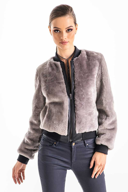 Woman wearing a gray fur jacket with a white background
