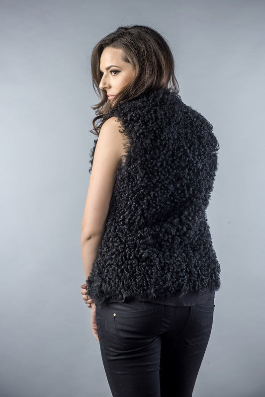 Woman wearing a black textured vest against a gray background