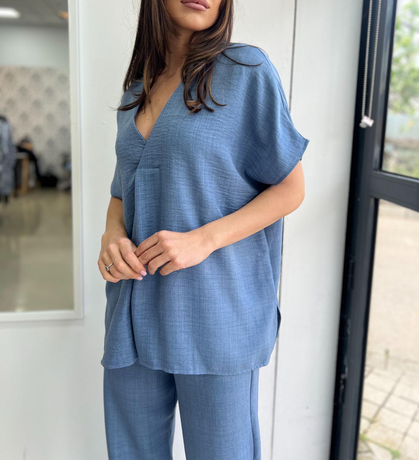 Woman wearing a blue outfit standing indoors.
