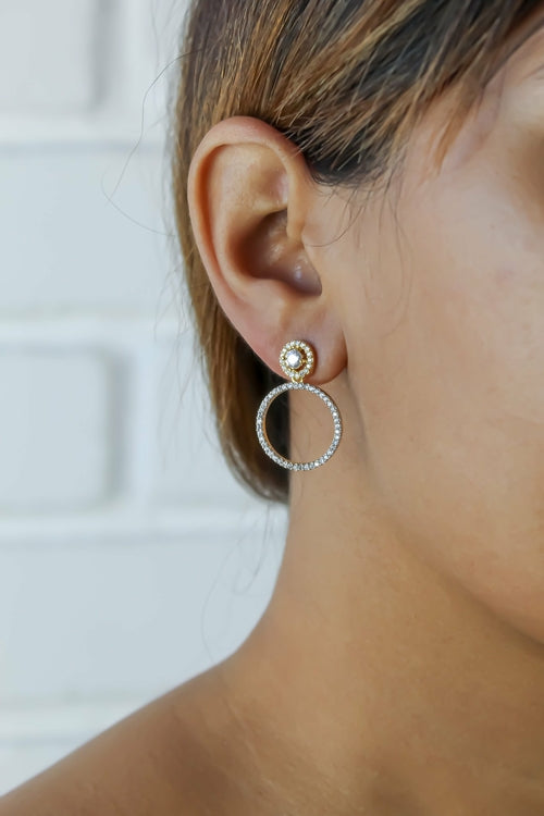 Close-up of an ear wearing a double hoop earring with a blurred background