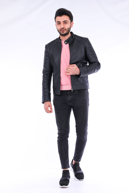 Man wearing a black leather jacket, pink shirt, and black jeans on a white background
