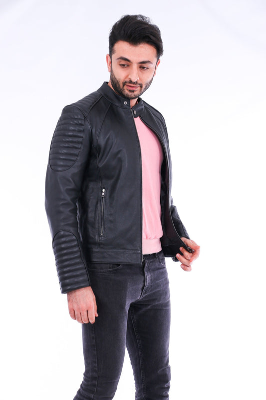 Man wearing a black leather jacket over a pink shirt on a white background