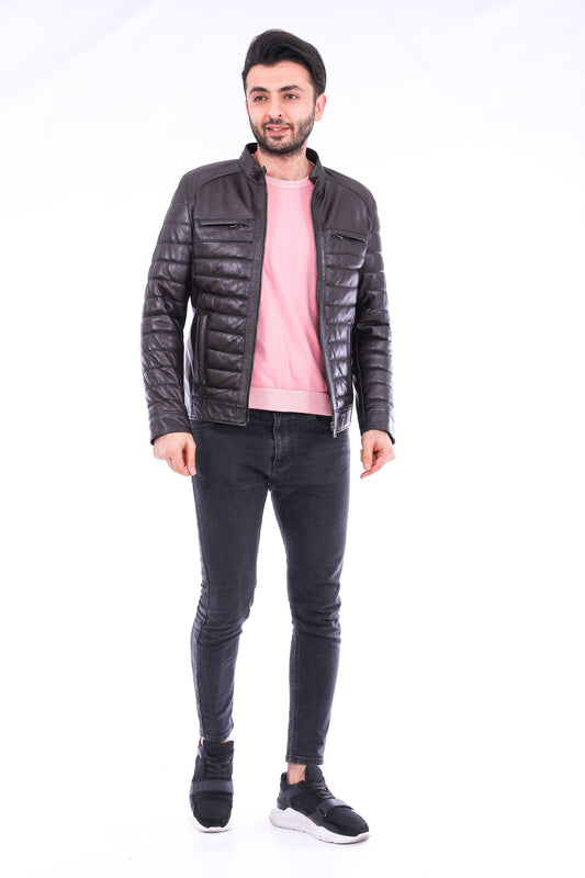 Man wearing a black leather jacket, pink shirt, and black jeans on a white background