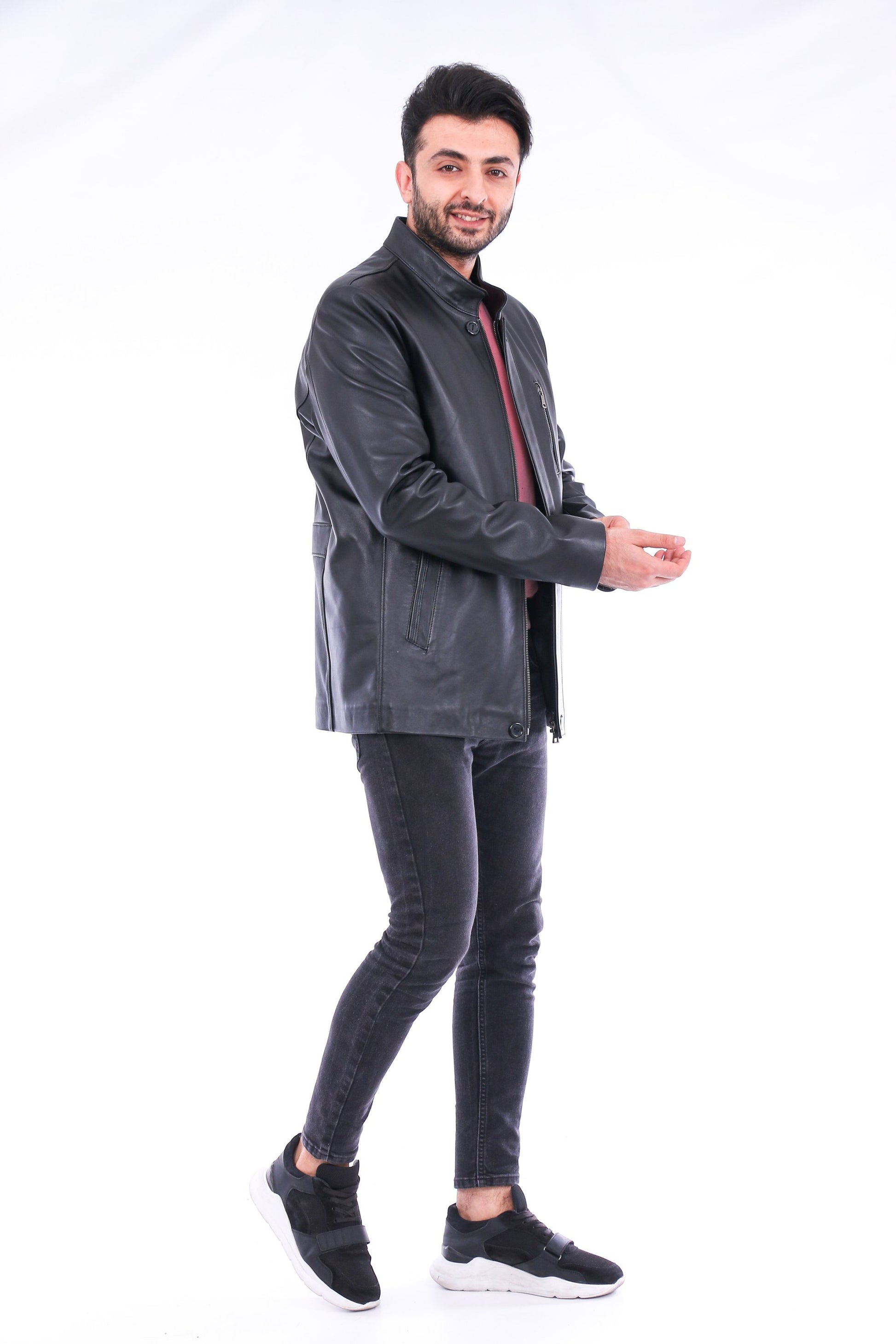 Man wearing a dark gray jacket and jeans on a white background