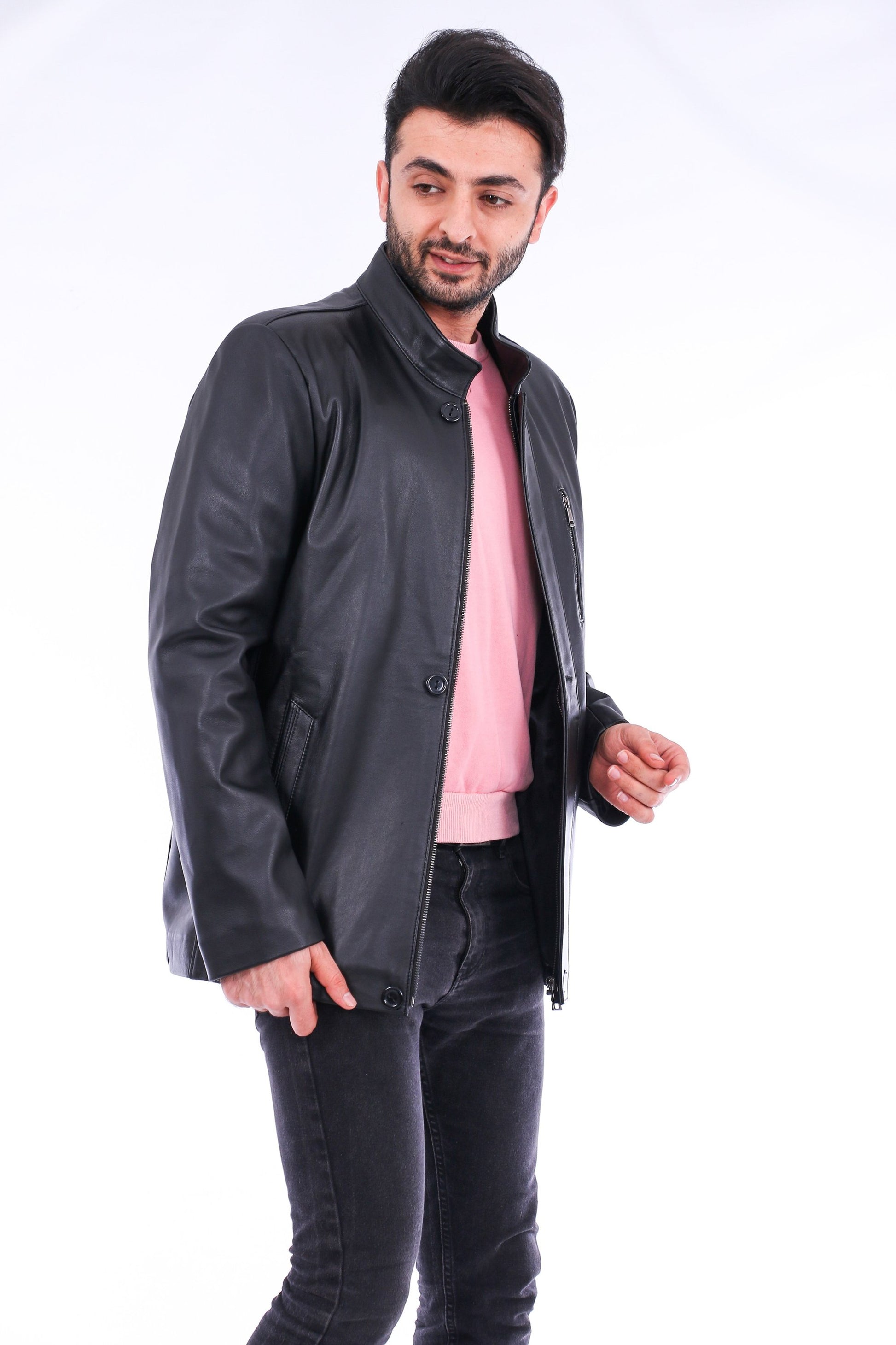 Man wearing a black jacket over a pink shirt on a white background