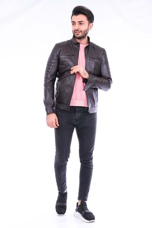 Man wearing a black leather jacket, pink shirt, and black jeans on a white background