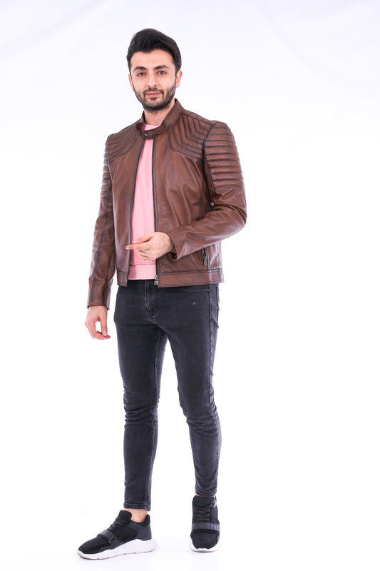 Man wearing a brown leather jacket, pink shirt, and black jeans on a white background