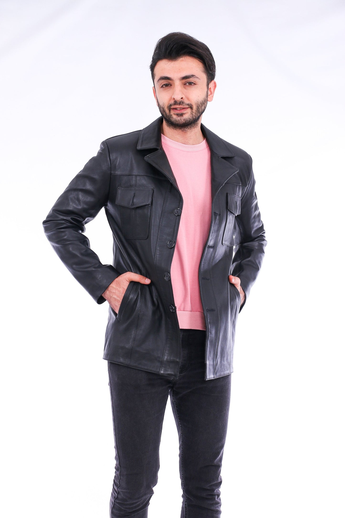 Man wearing a black leather jacket over a pink shirt on a white background