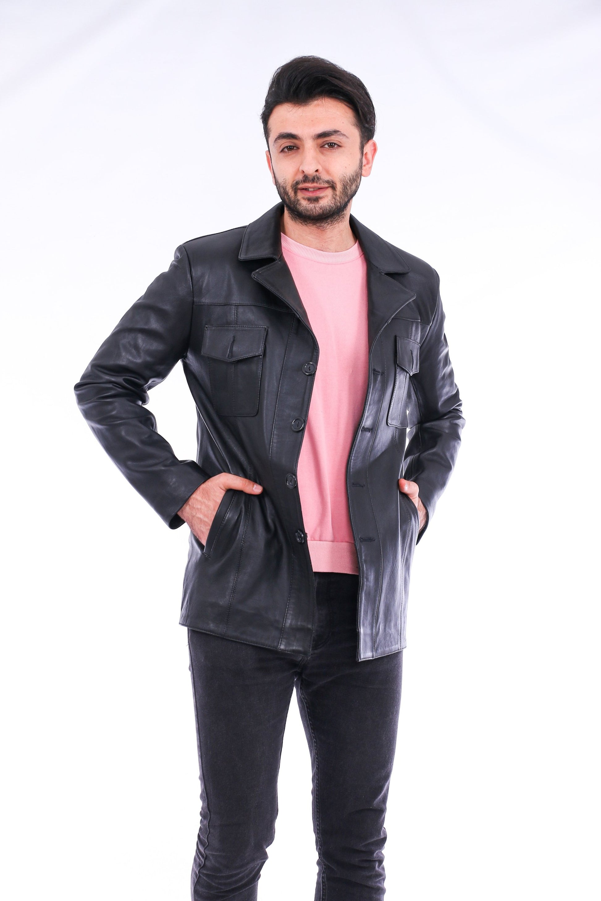 Man wearing a black leather jacket over a pink shirt on a white background