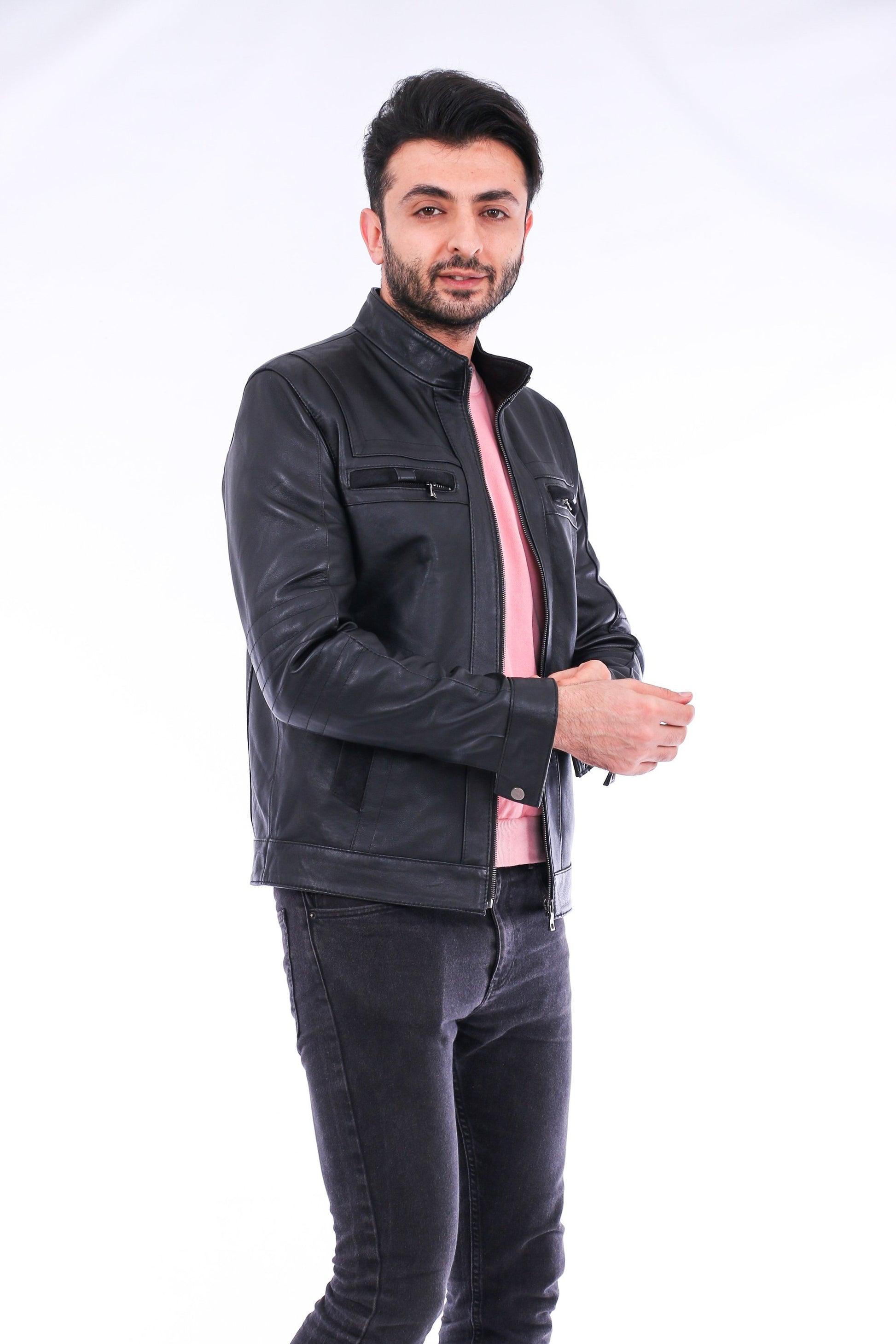 Man wearing a black leather jacket and dark jeans on a white background