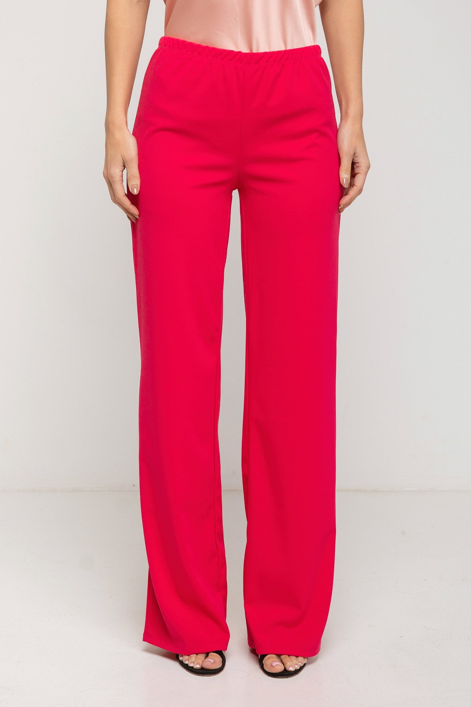 Person wearing bright pink pants on a white background