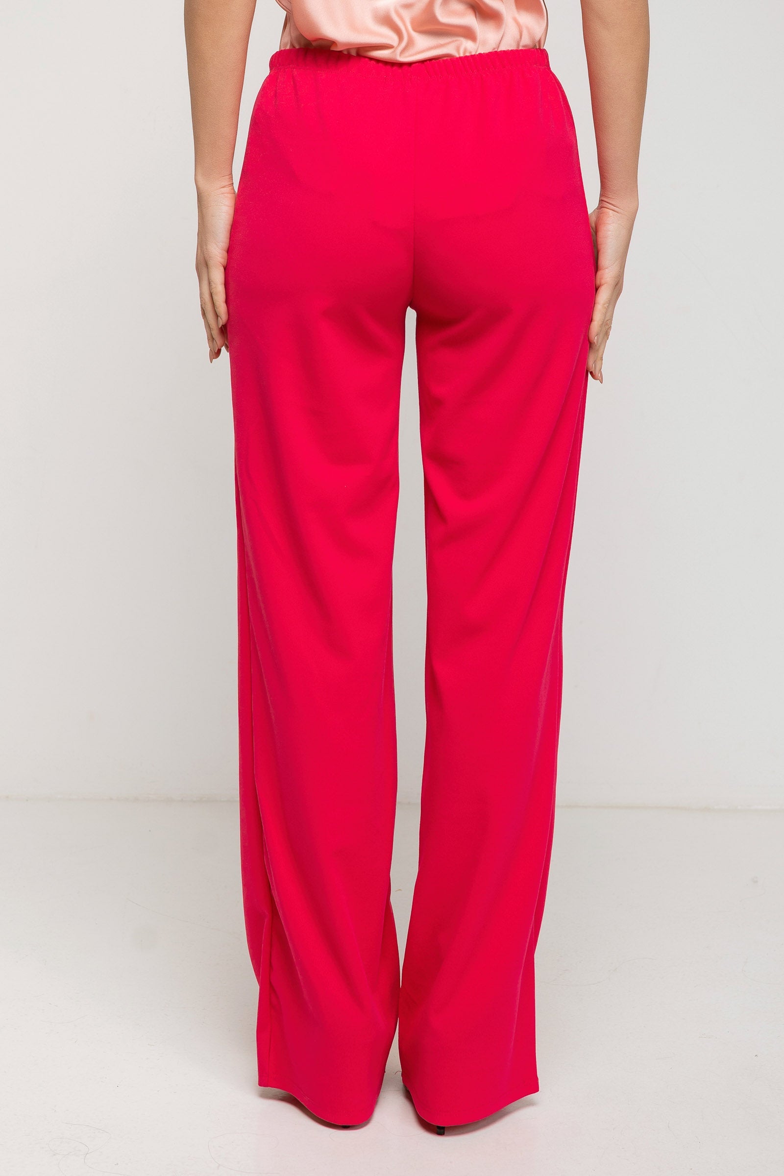 Red pants worn by a person on a white background