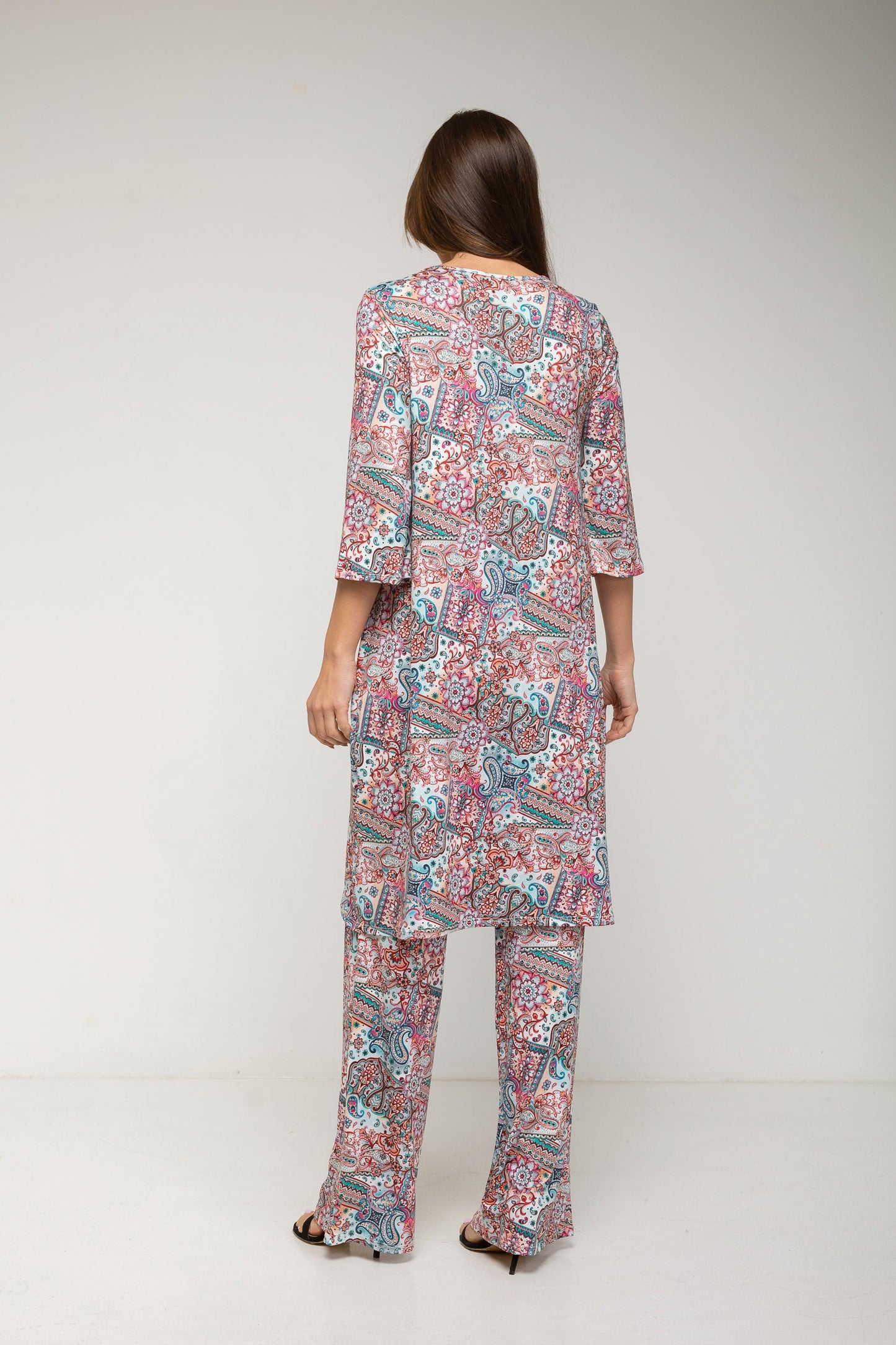 Woman wearing a patterned outfit on a plain background