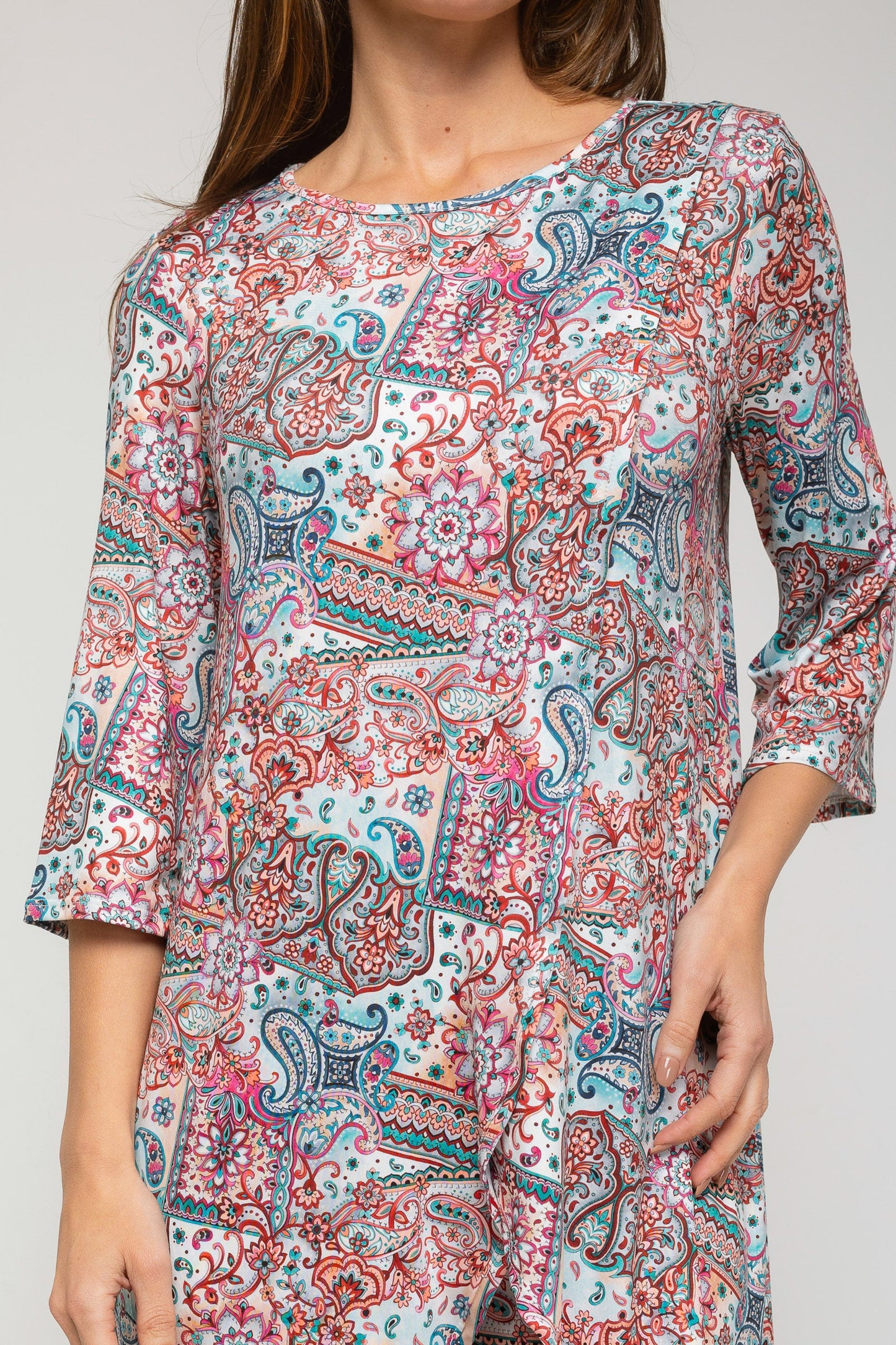 Woman wearing a colorful patterned dress on a plain background