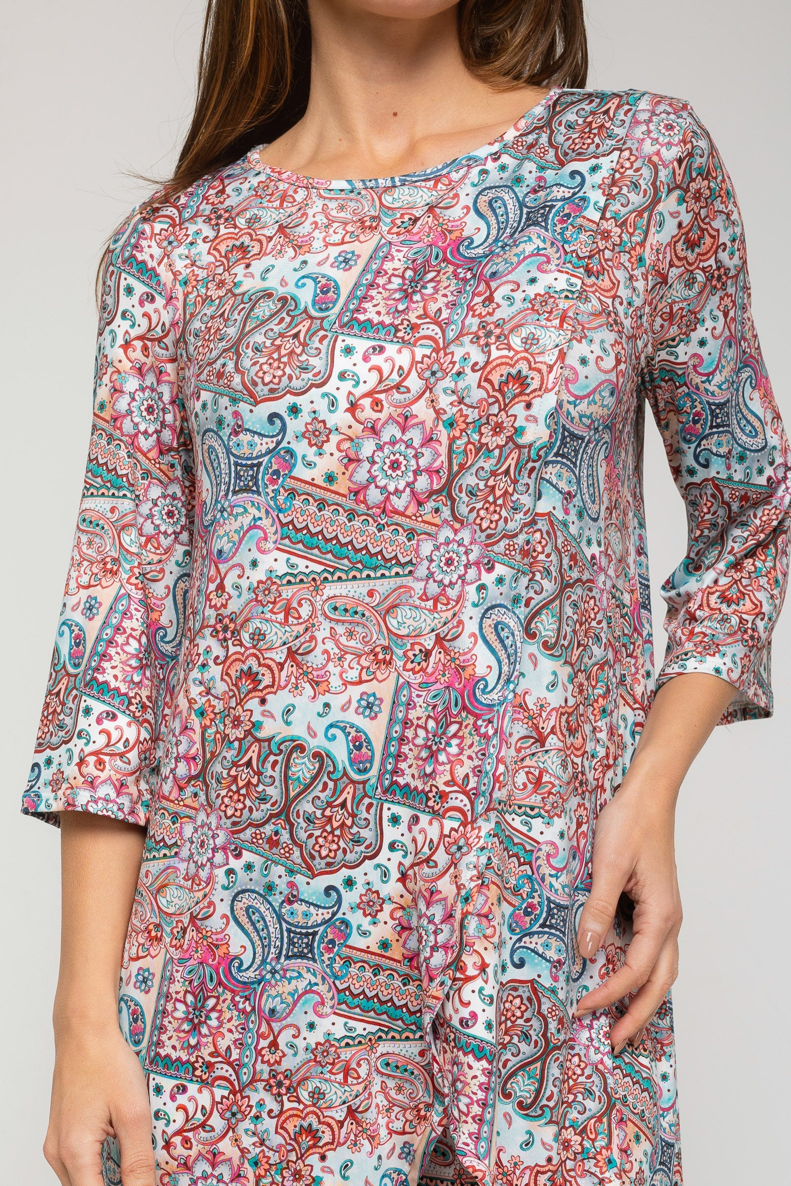 Woman wearing a colorful patterned dress on a plain background