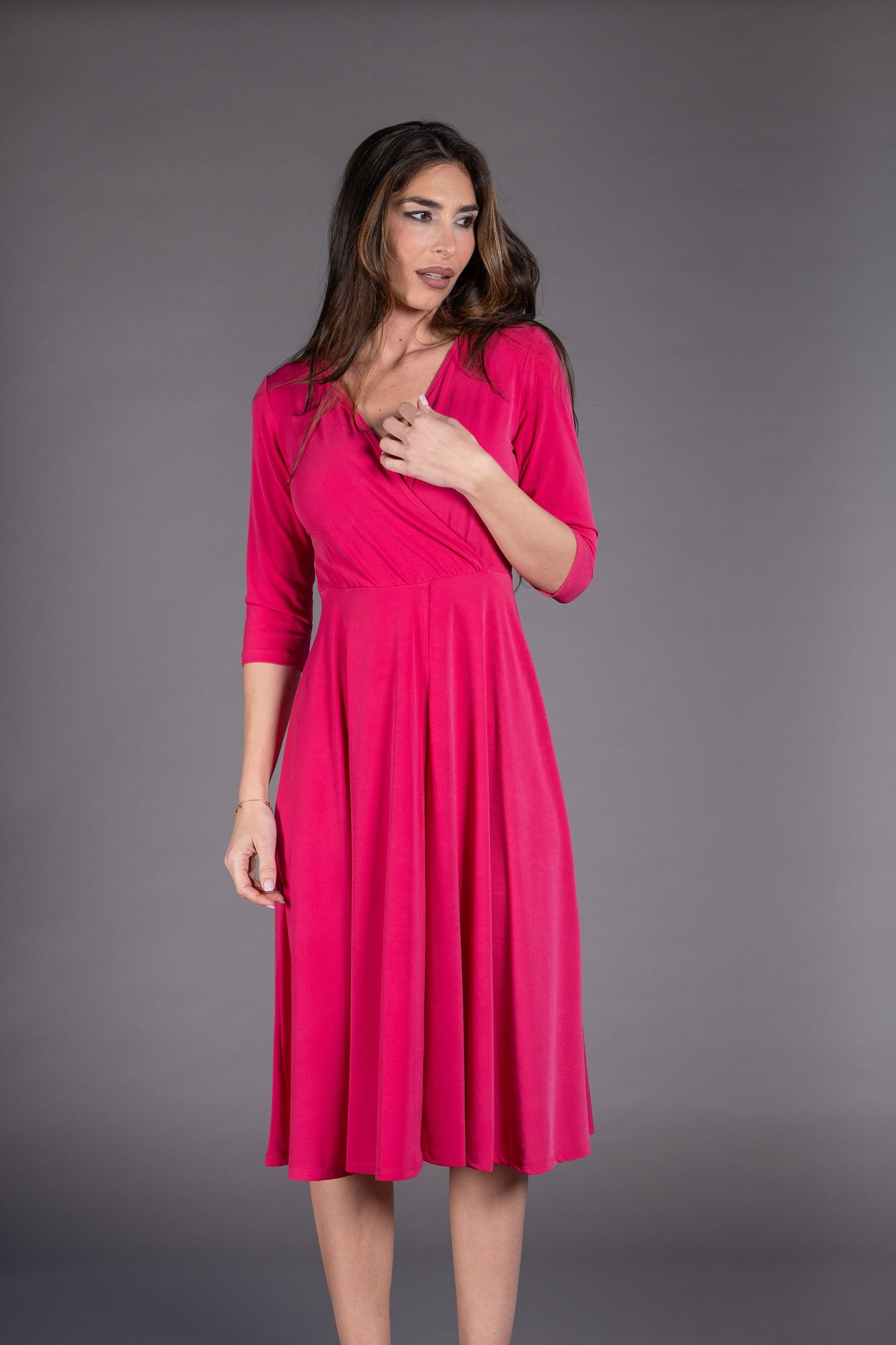 Woman wearing a pink dress against a gray background