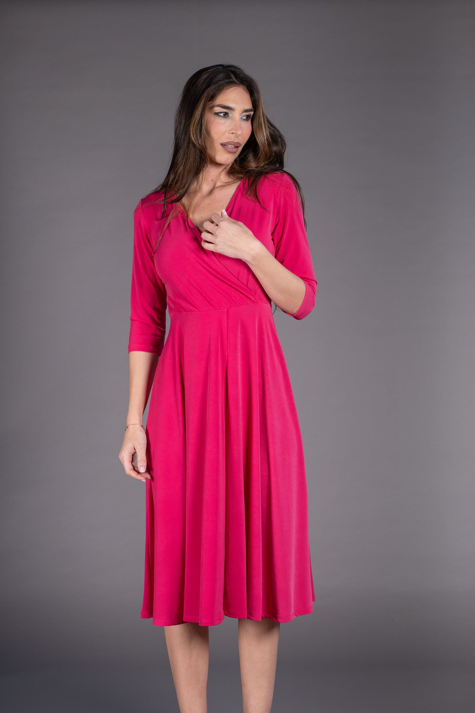 Woman wearing a pink dress against a gray background