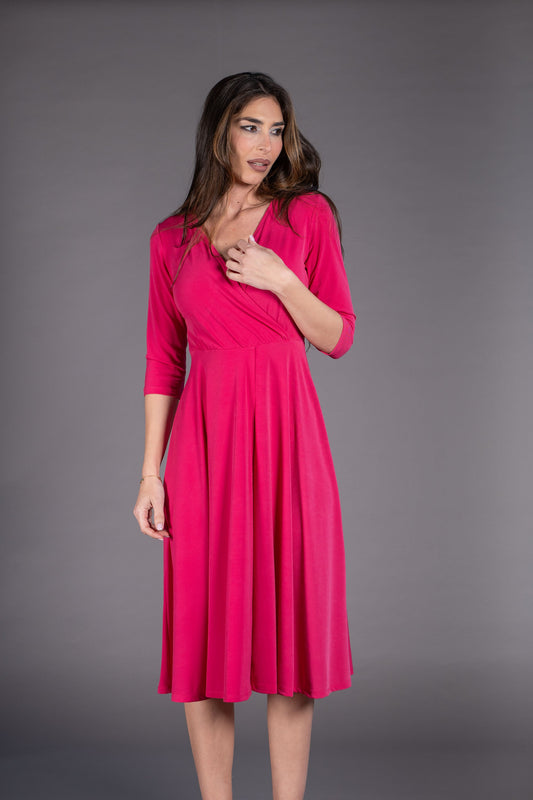 Woman wearing a pink dress against a gray background