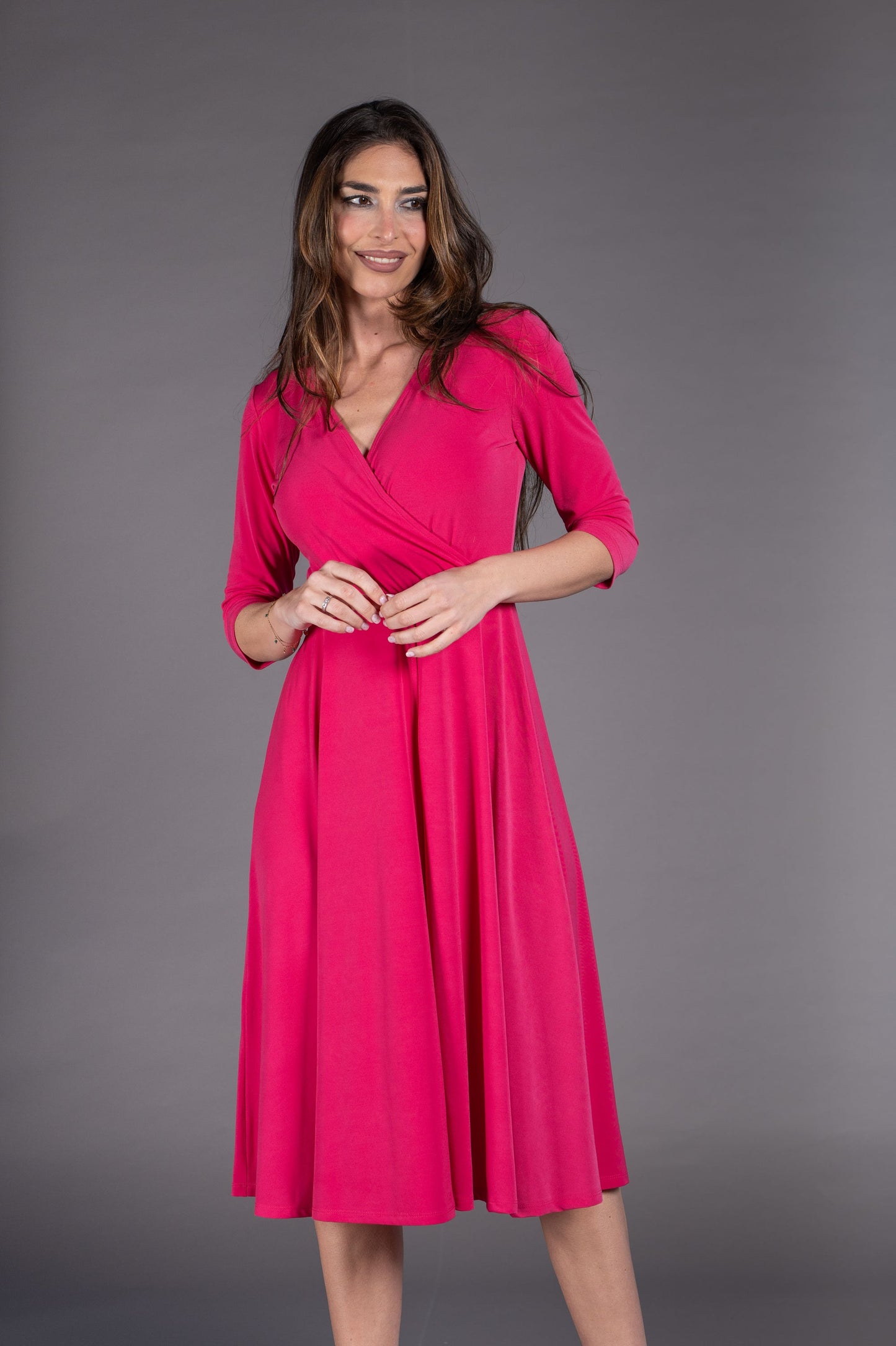 Woman wearing a pink dress against a gray background