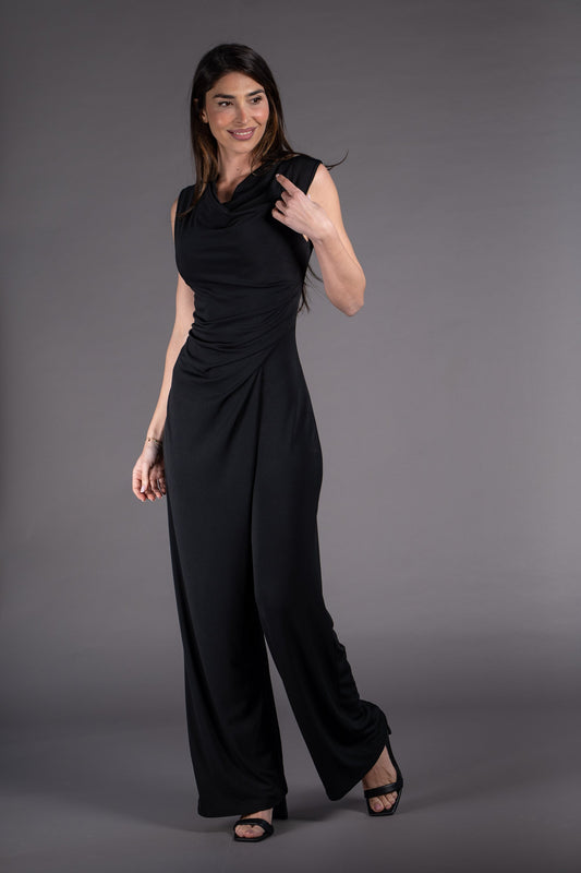 Woman wearing a black sleeveless jumpsuit against a gray background