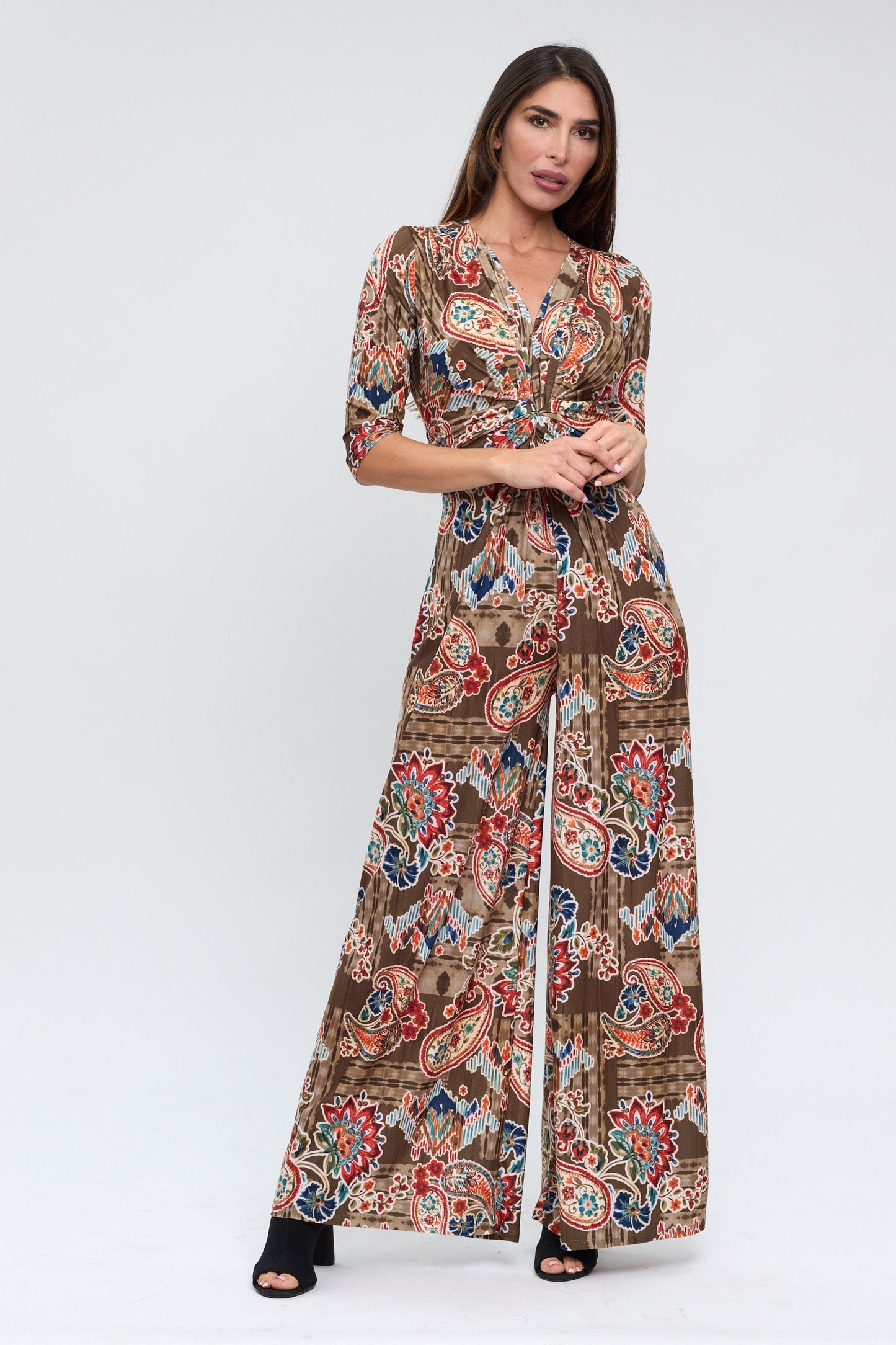 Woman wearing a patterned jumpsuit on a white background