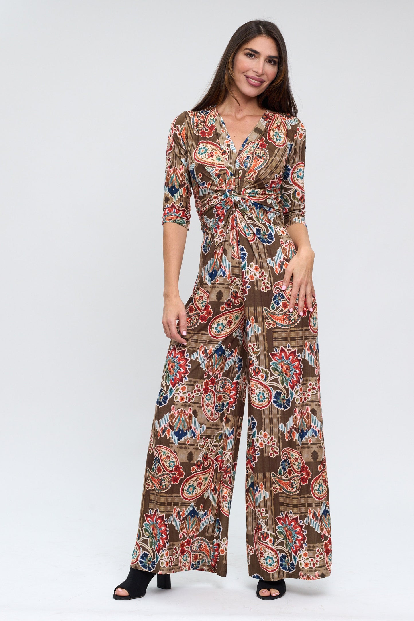 Woman wearing a patterned jumpsuit on a white background