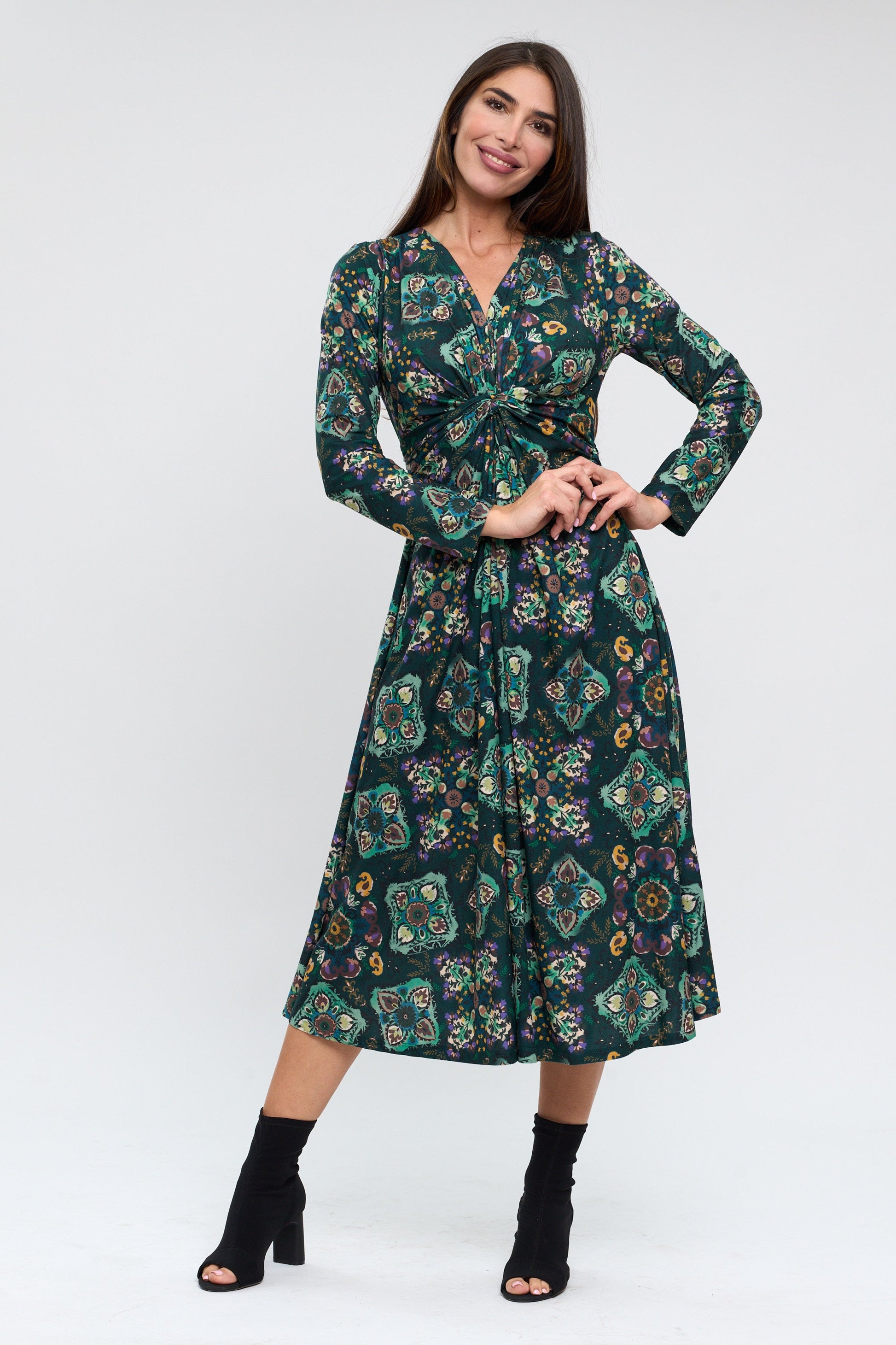 Woman wearing a long-sleeve, patterned dress on a white background