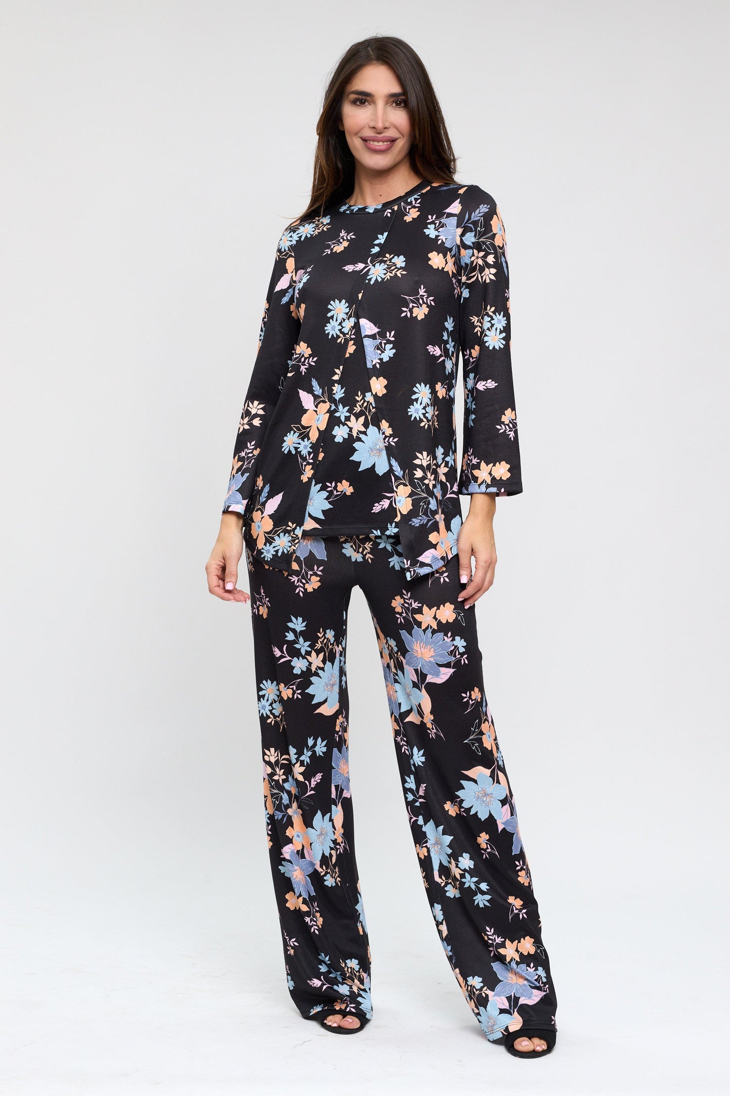 Woman wearing a black floral jumpsuit on a white background