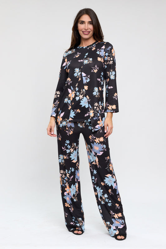 Woman wearing a black floral jumpsuit on a white background