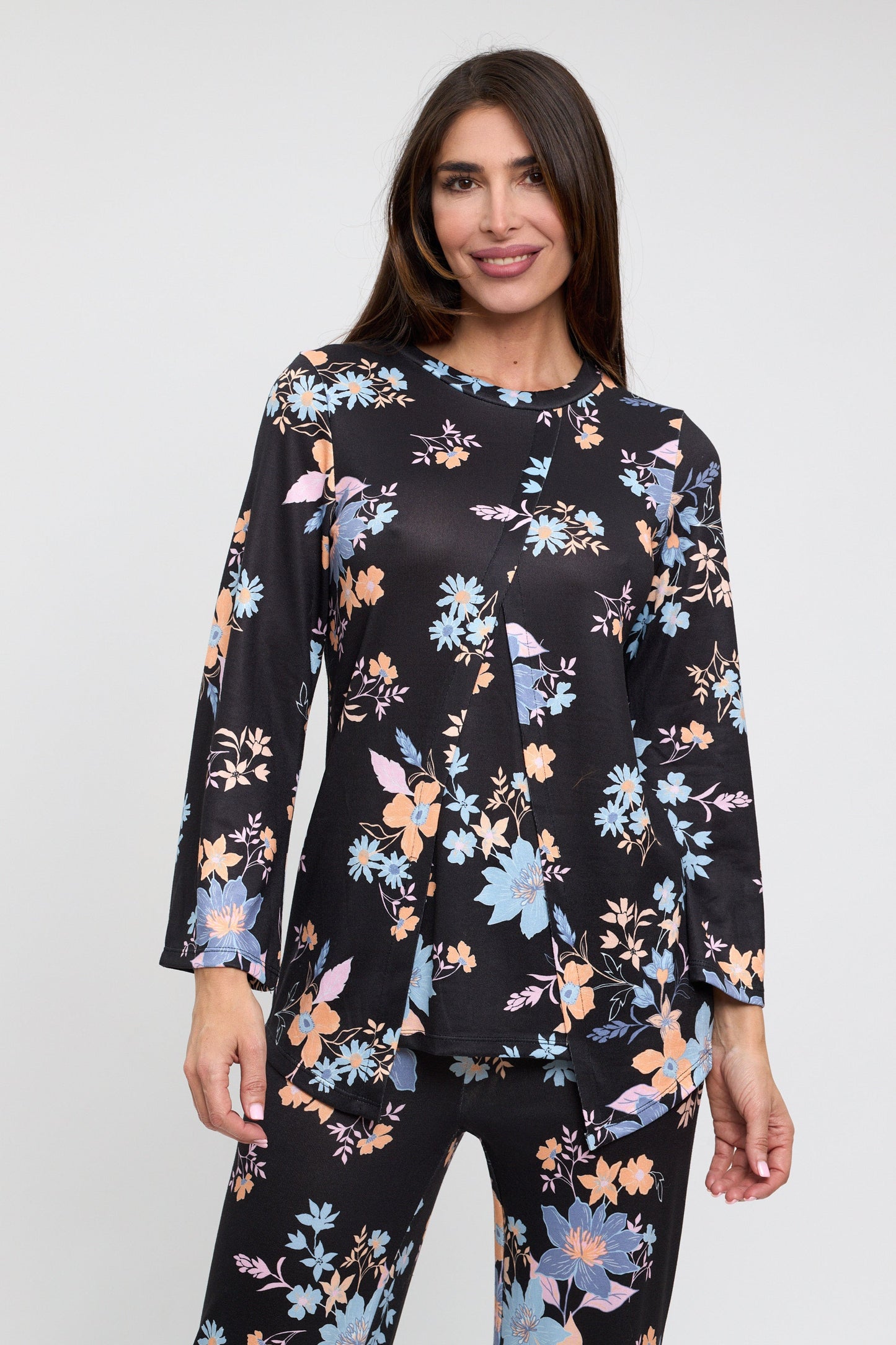 Woman wearing a black floral long-sleeve top and pants on a white background