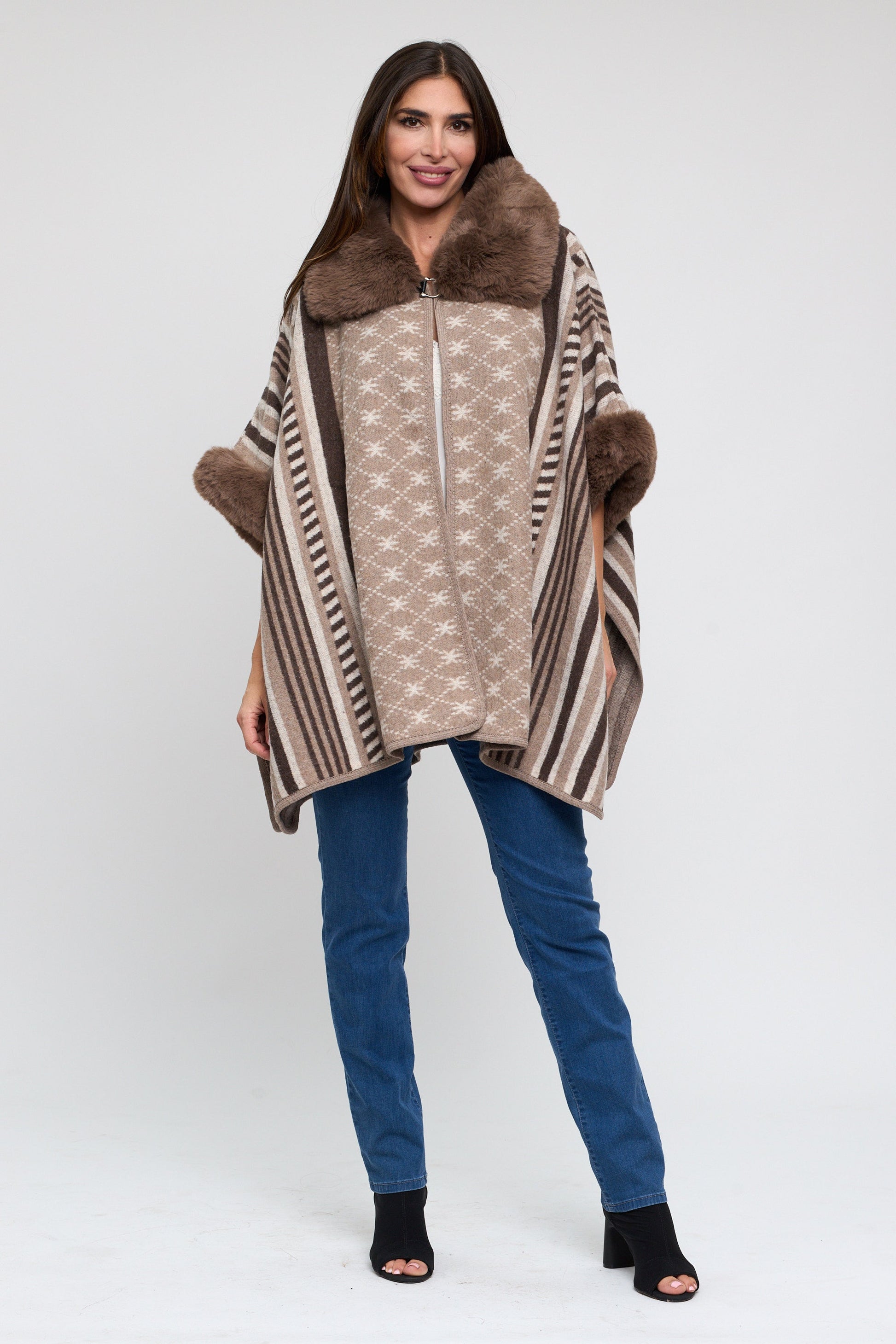 Woman wearing a patterned poncho with fur trim on a white background