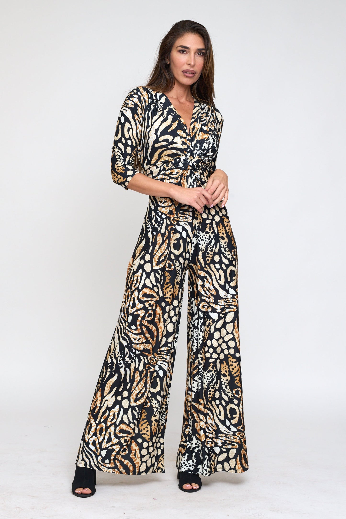 Woman wearing a patterned jumpsuit on a white background