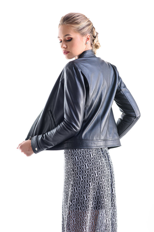 Woman wearing a black leather jacket and patterned pants on a white background