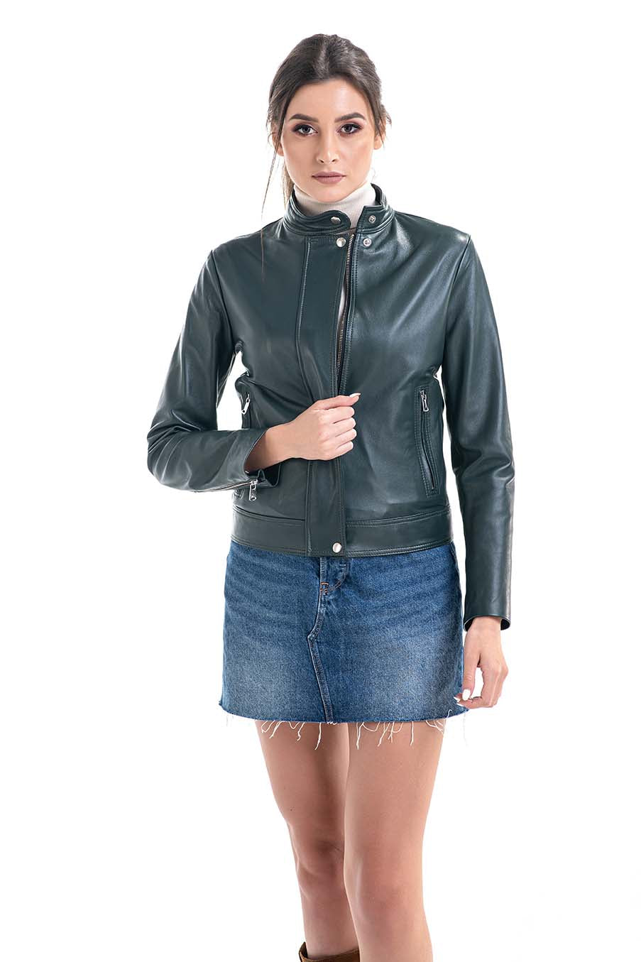 Woman wearing a green leather jacket and blue denim skirt on a white background