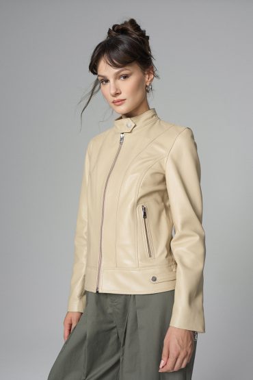 Woman wearing a beige leather jacket on a gray background