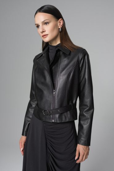 Woman wearing a black leather jacket against a gray background